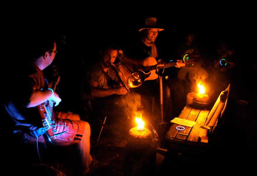Photograph of musicians playing around fire